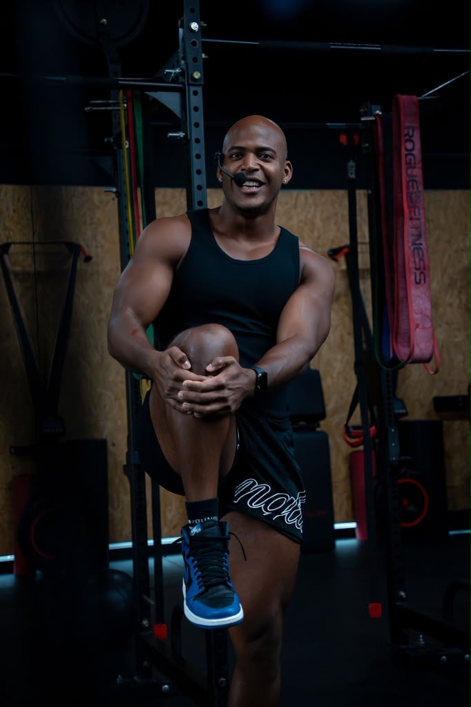Coach smiling while stretching in the gym